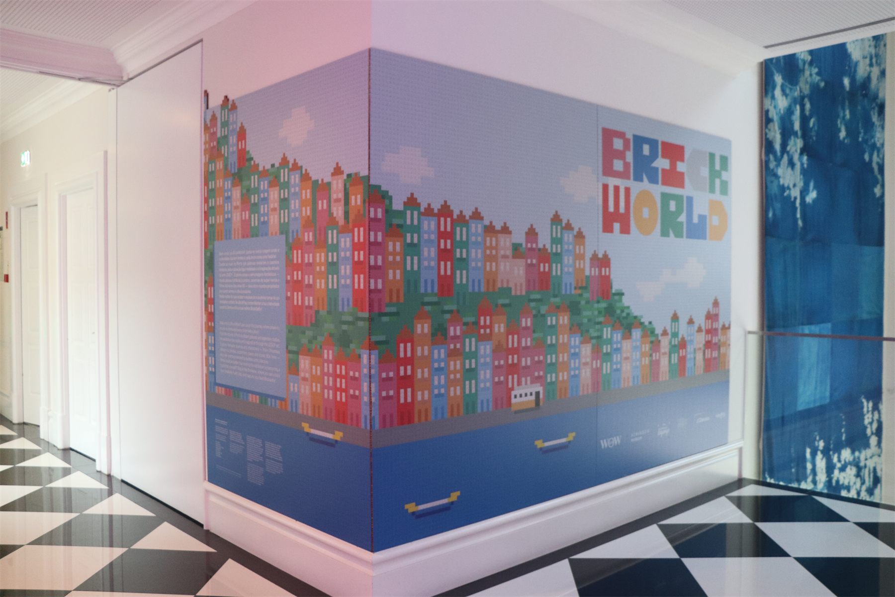 A corridor with the Porto skyline rendered as a pixel mural, over a chequerboard floor