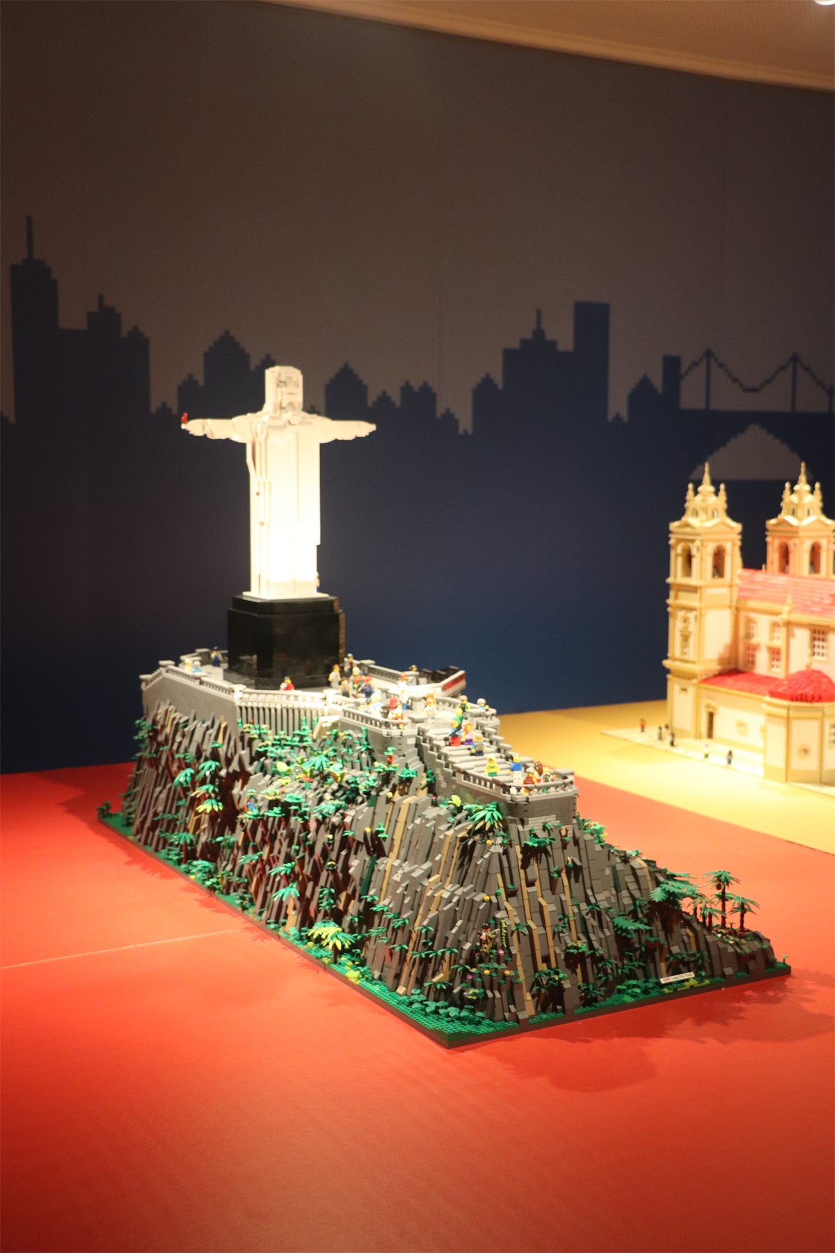 A large LEGO build of Rio de Janeiro, lit against a red wall
