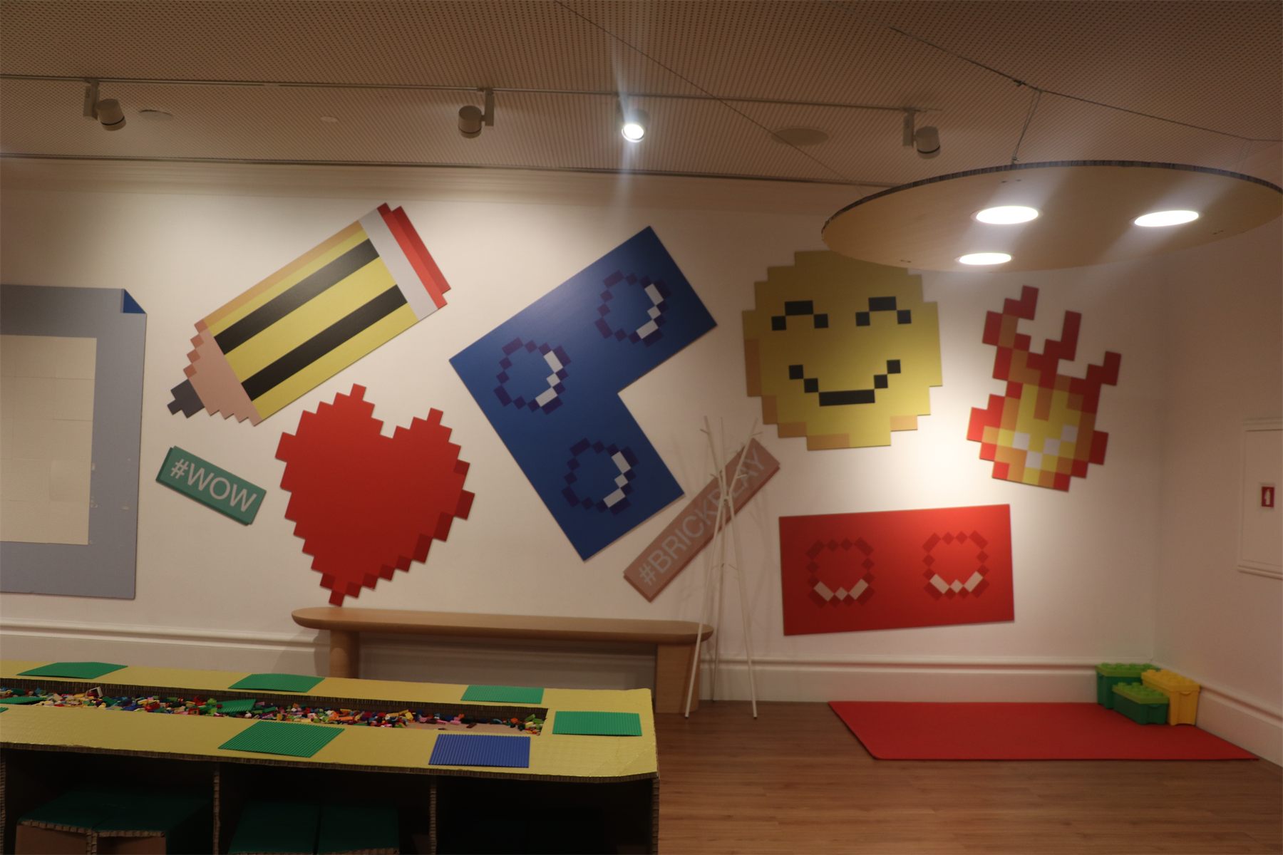 The finished workshop room, with build tables and pixel artwork on the walls
