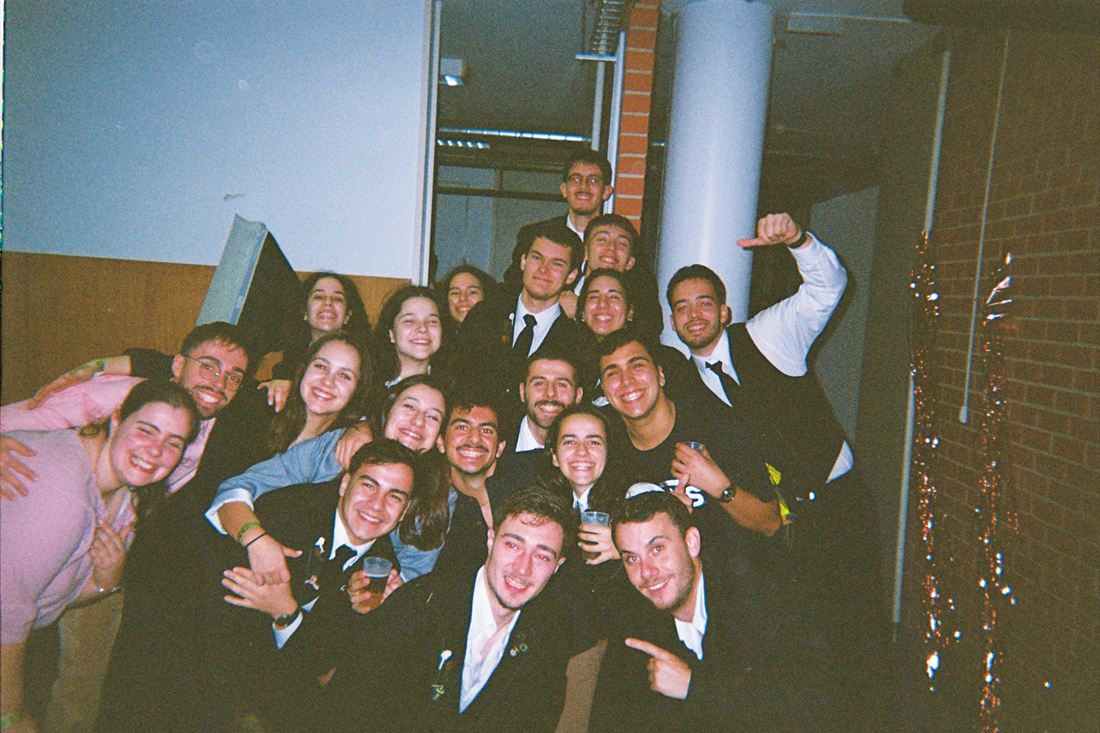 A large group of friends at an event, arms around each other