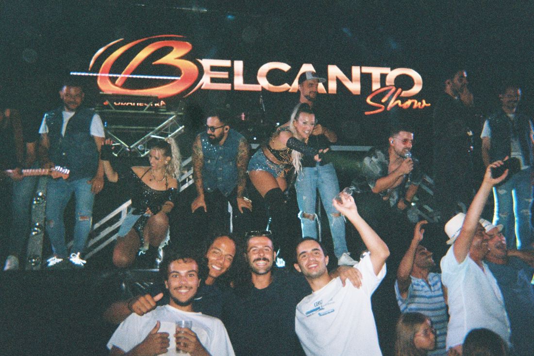 A group photographed in front of a lit stage sign