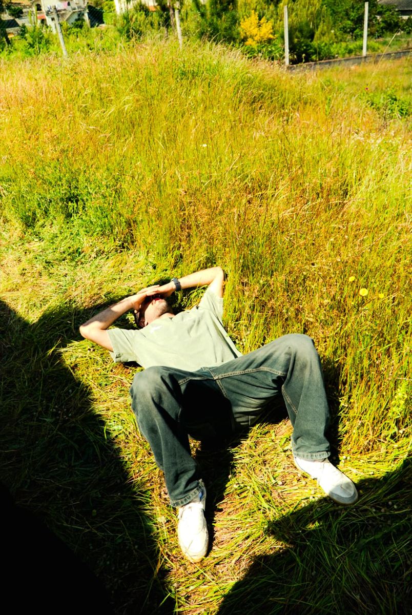 Lying in long grass in the sun, hands behind the head