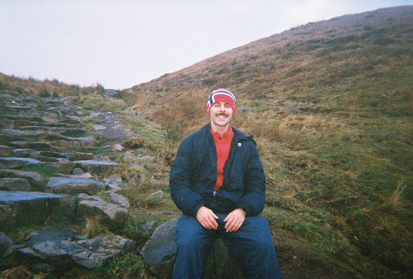 Sitting on a rock on a Scottish hillside in a Norwegian beanie