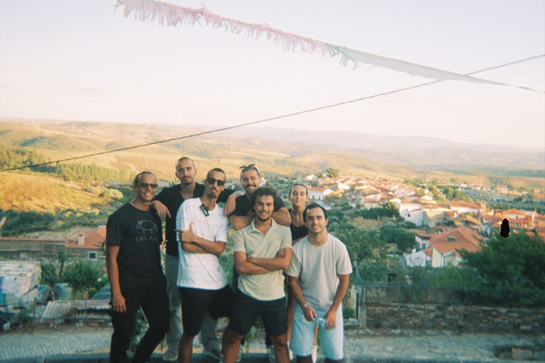 A group standing on a hillside with a village and open country behind