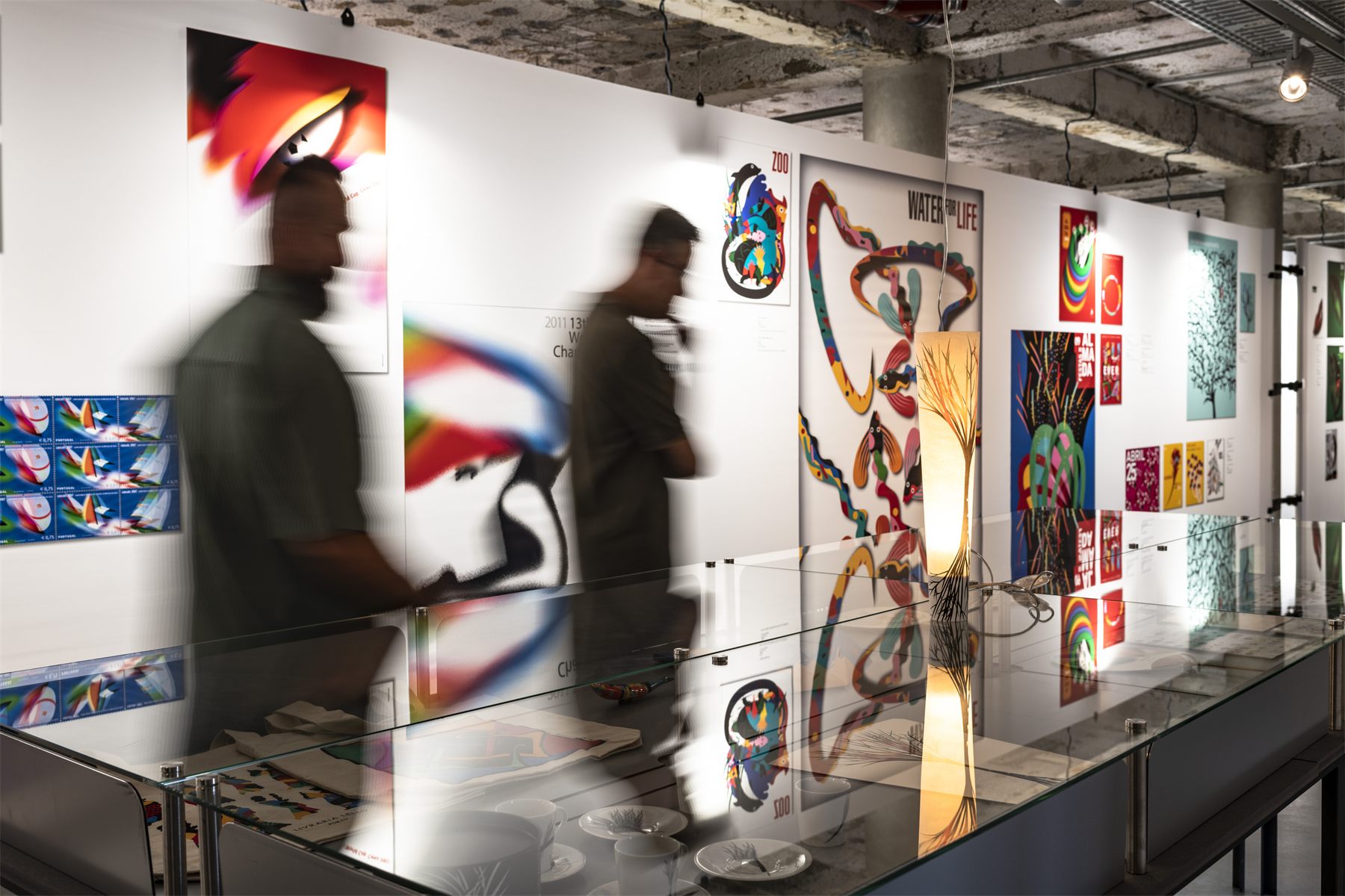 Visitors moving through the finished exhibition between backlit fabric panels
