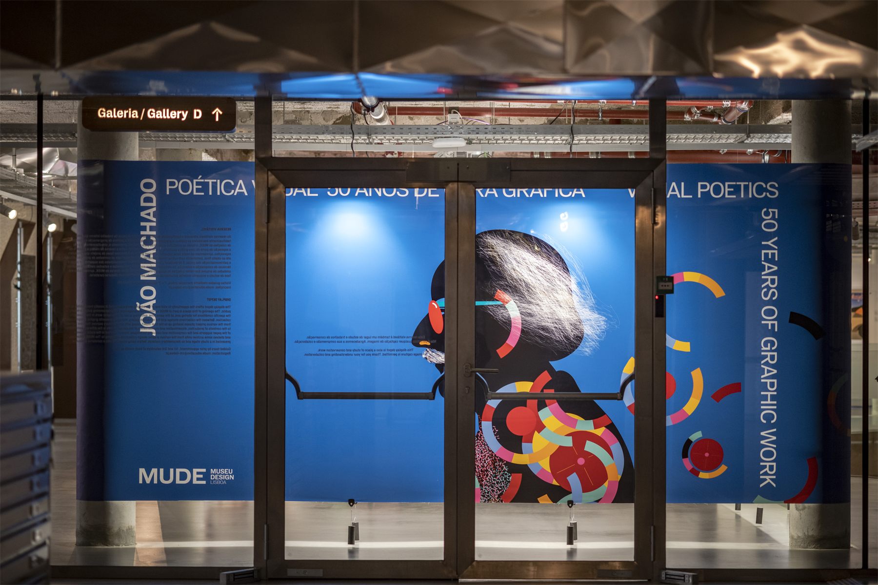 The same corner panel seen from the lobby through the glass doors of the gallery