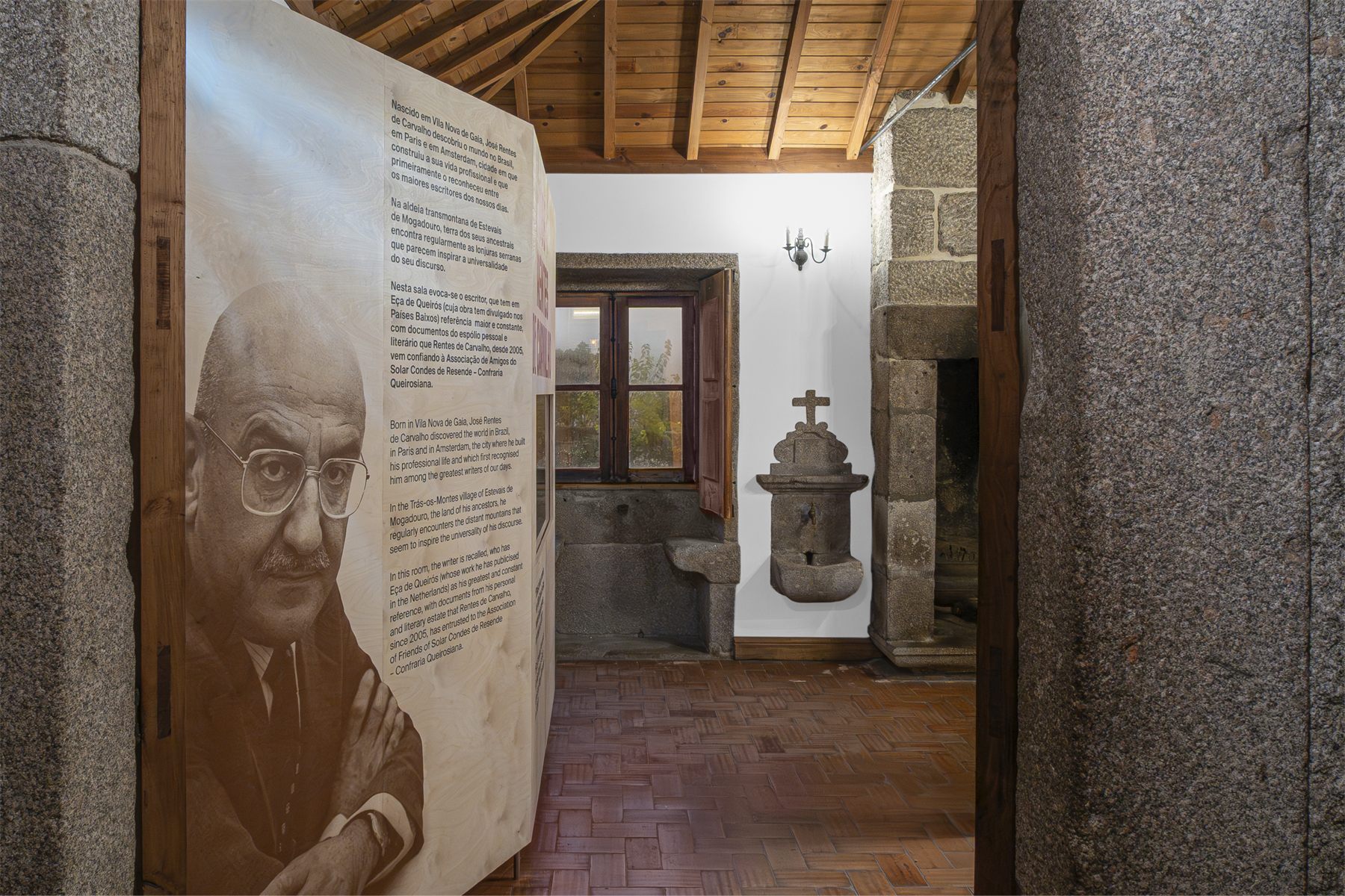 A plywood insert carrying a portrait of the writer, set against a granite wall