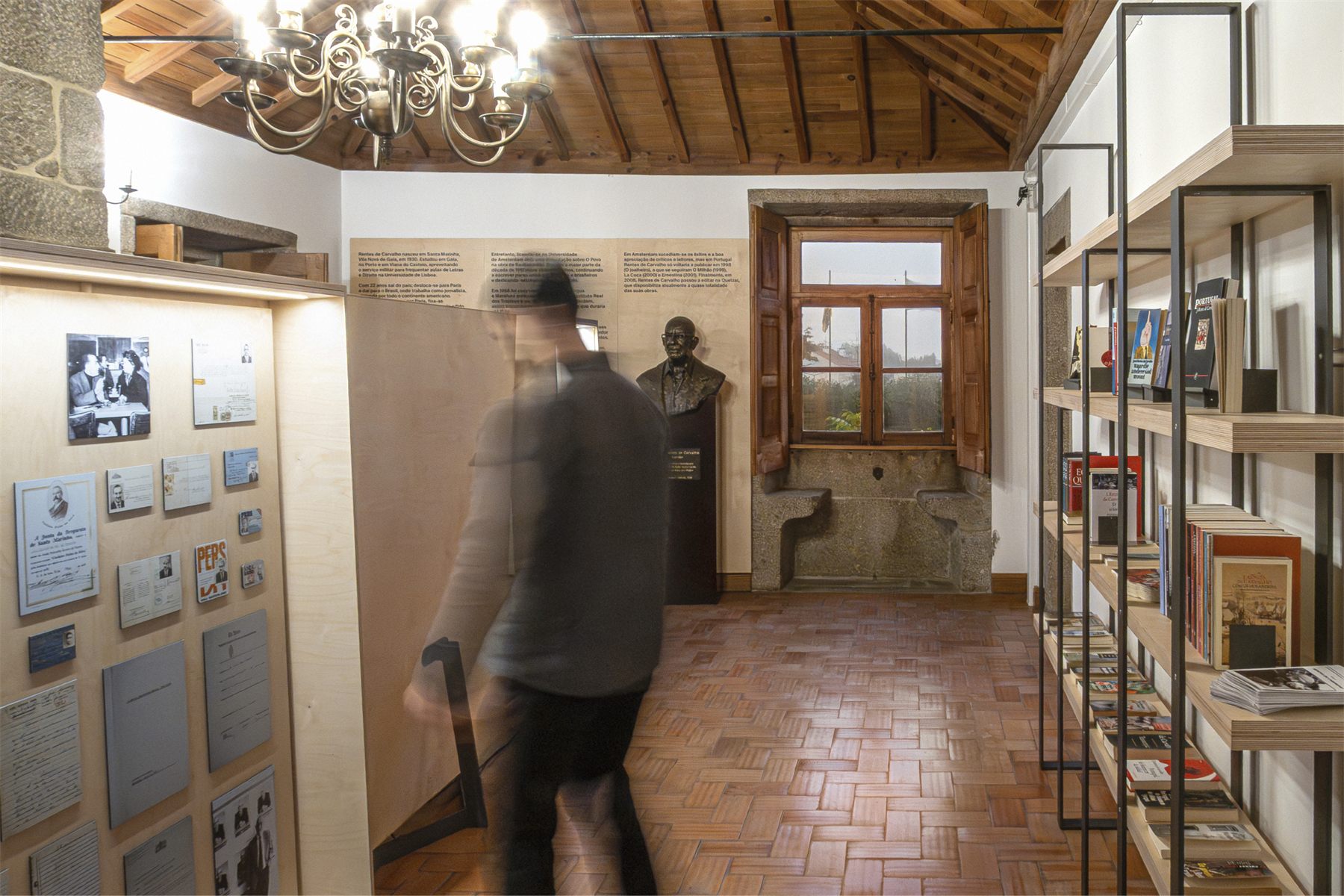 A sequence of tall vitrines along the room, lit from within