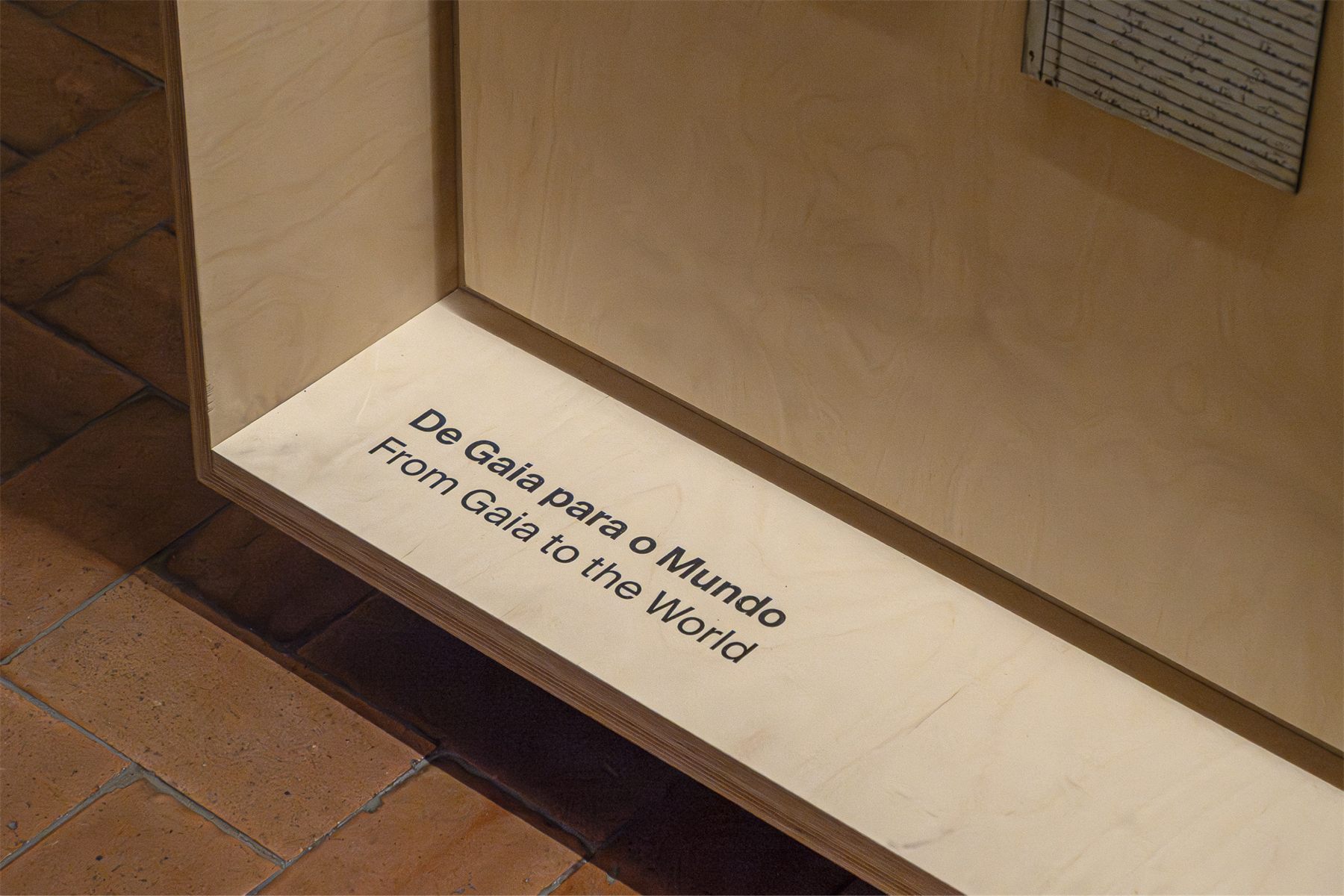 The angled base of a vitrine, carrying the line De Gaia para o Mundo