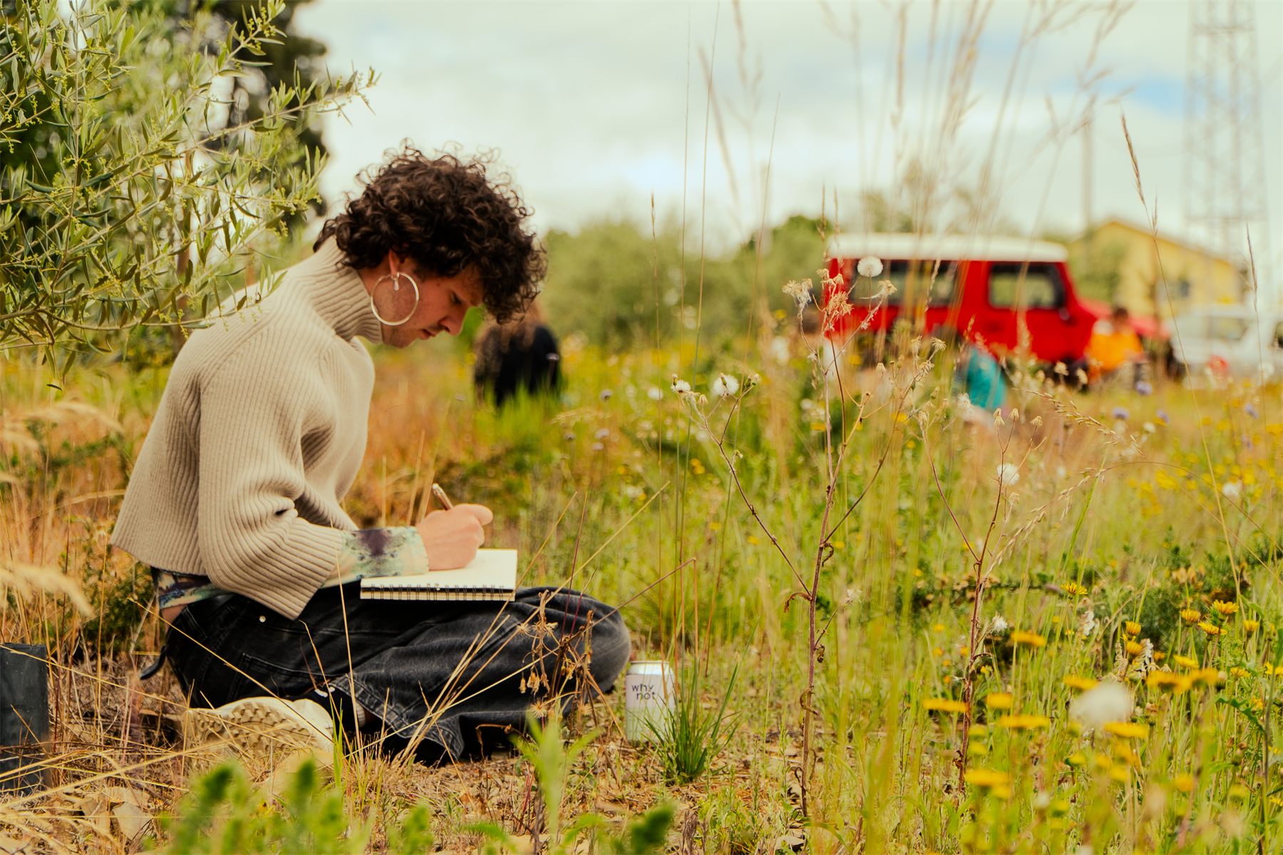 Sketch Fest: a participant drawing in a meadow in the Alto Douro